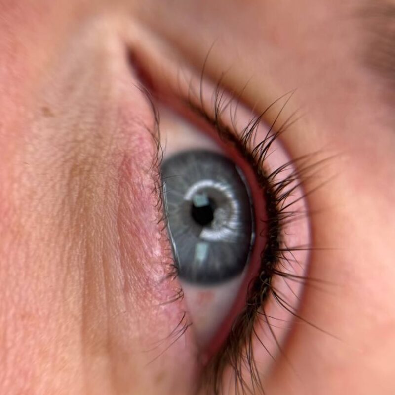 Close-up of a blue eye with a freshly tattooed lash-line eyeliner enhancement by Lindsey.